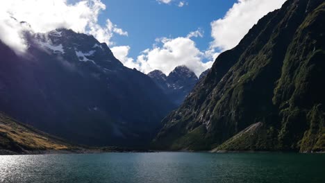 time lapse shot of beautiful lake marian and flying clouds behind mountains in summer