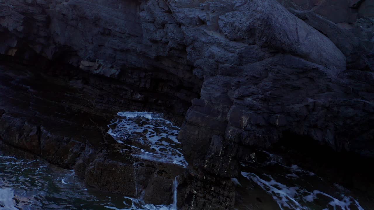 Dramatic Ocean Waves Crashing Against Dark Rocky Coast