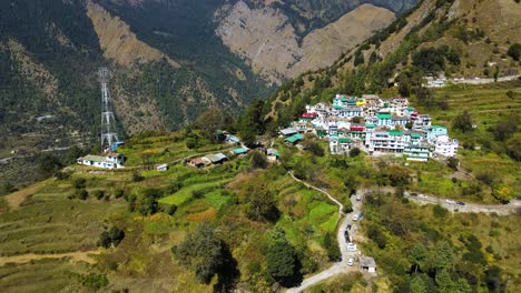 una toma aérea de un dron capturando un pintoresco pequeño pueblo anidado en las altas montañas rodeado de exuberante vegetación.