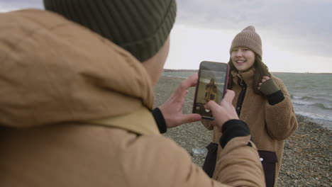 vista traseira do adolescente segurando um smartphone