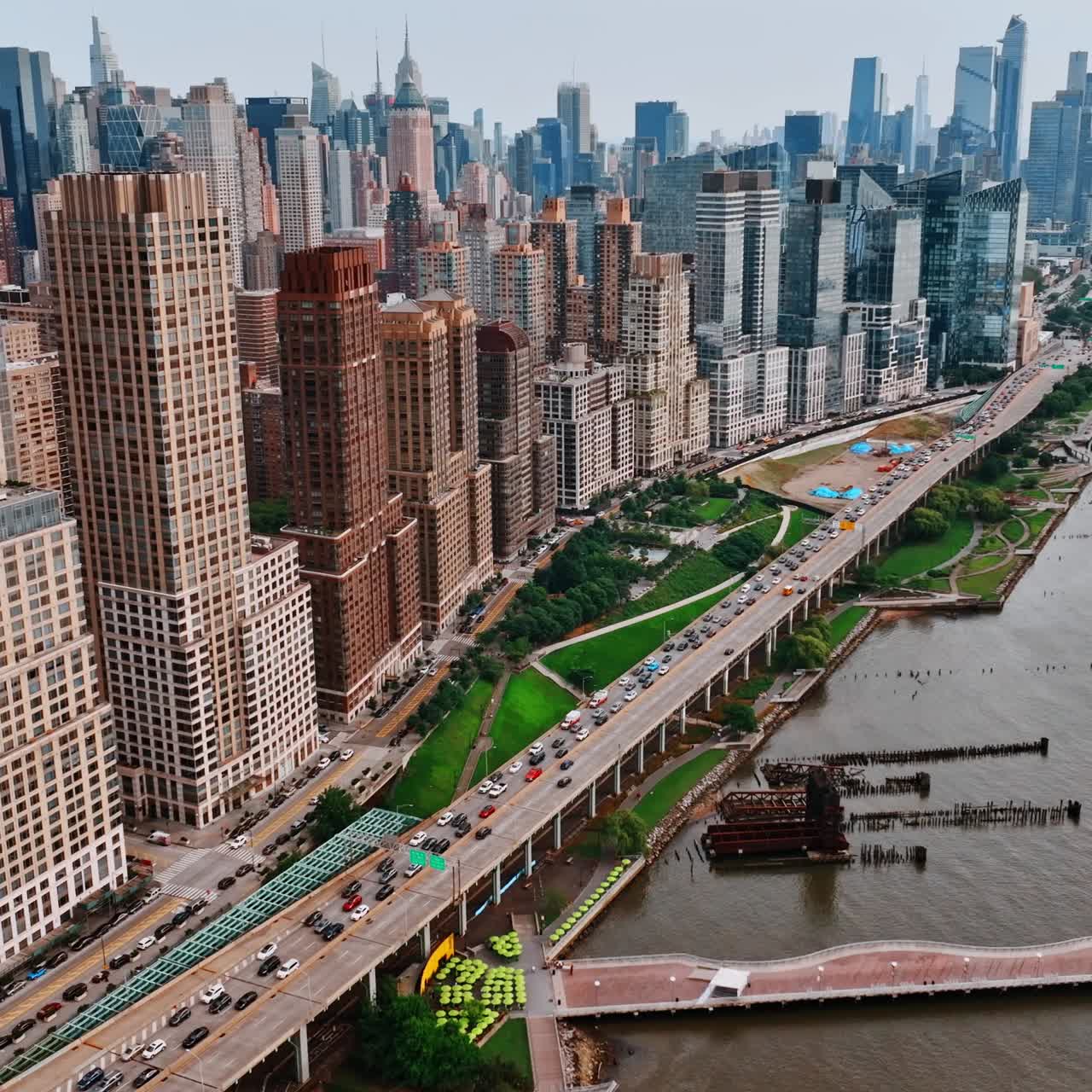 Drone footage over waterfront of New York. Manhattan view with busy traffic on the roads. Aerial perspective