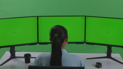 person working at a triple monitor setup