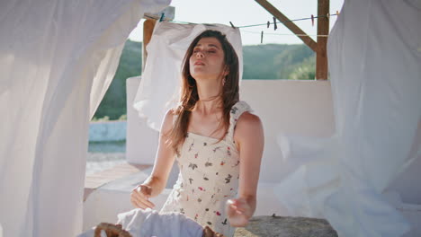 ama de casa poniendo la cesta de la ropa en la terraza de viento de primer plano. mujer rutina doméstica