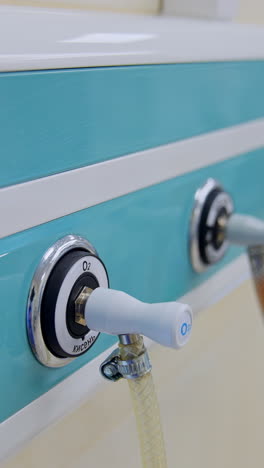 blue panel with plugged tubes for oxygen supply to artificial lung ventilation apparatus in surgical room. close up. blurred backdrop. vertical video