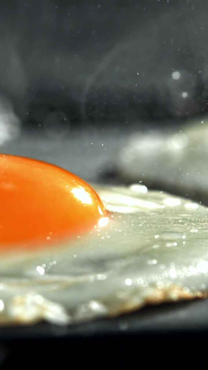 Close-up of a Fried Egg Sizzling in a Hot Pan