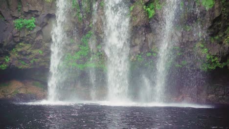 toma en cámara lenta de una cascada que se estrella contra un lago natural en mauricio - tiro medio