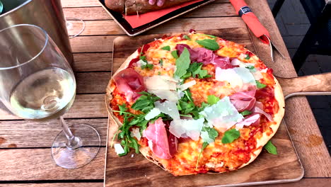 tasty pizza with arugula and serrano ham, plus a delicious glass of white wine in the restaurant