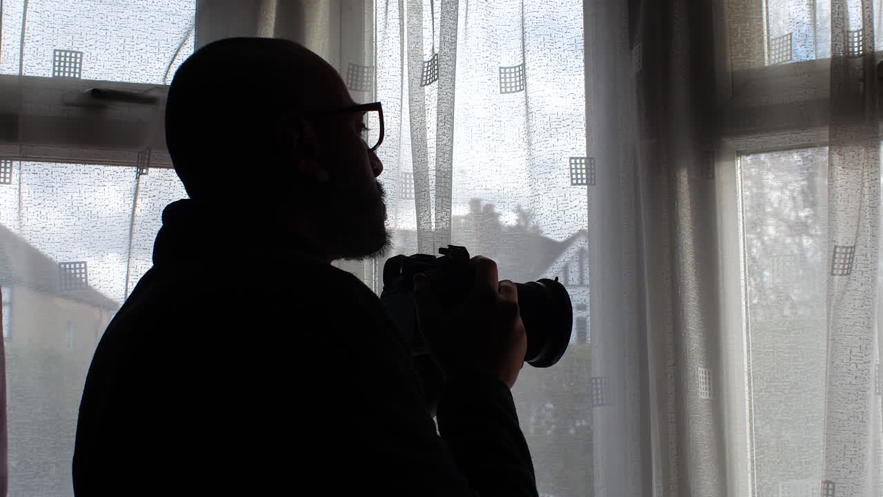 Man Taking Picture With Camera Out Of Window At Home - Close Up