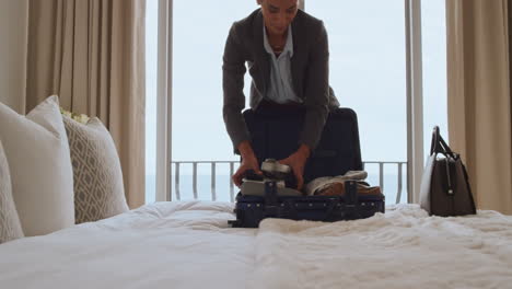 beautiful business woman packing suitcase in hotel room getting ready for road trip preparing luggage making travel plans