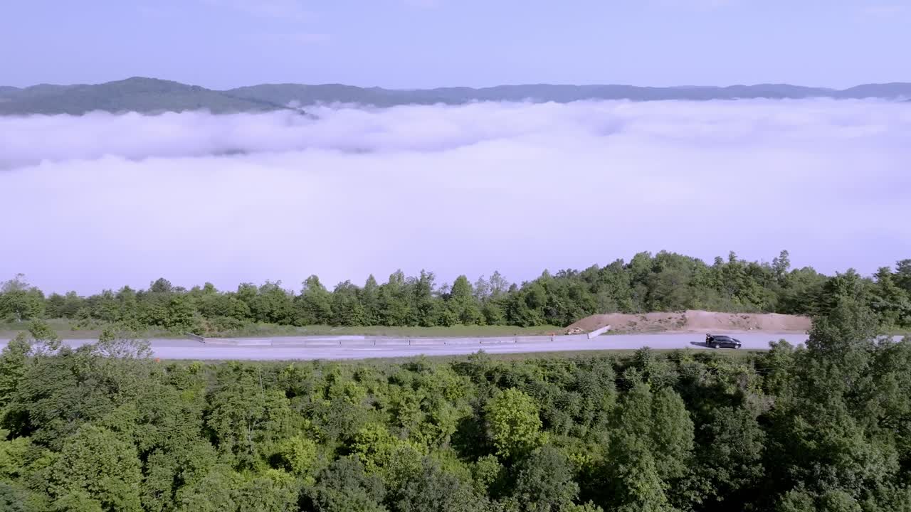 테네시 주 젤리코 근처의 interstate 75에서 교통과 함께 구름과 안개, 버랜드 산맥에서 드론 비디오와 함께 나무 위로 이동합니다.