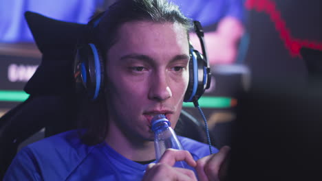 man drinking water while gaming