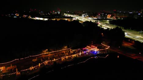 midnight traffic in katowice city, three pounds location - illuminated roads and lakeside bar - drone 4k