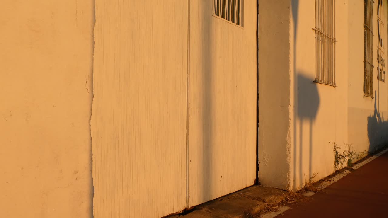 여름날 거리의 벽에 비친 자전거를 타는 남자의 그림자