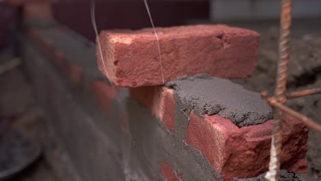 Nahaufnahme-Eines-Erfahrenen-Tischlers-Auf-Der-Baustelle,-Der-Eine-Mauer-Aus-Ziegeln-Und-Beton-Baut