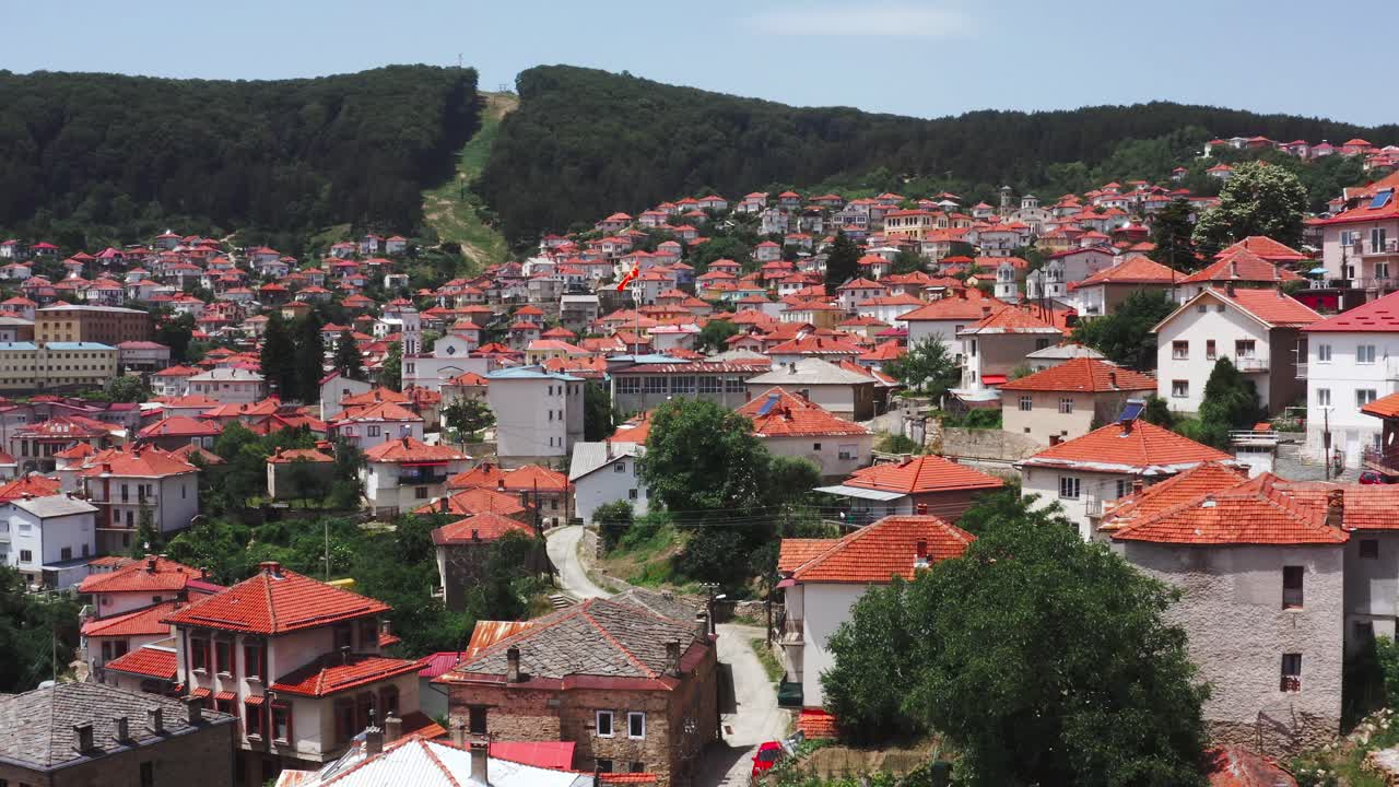 sobrevuelo aéreo de la hermosa ciudad de krushevo en macedonia con sus tejados rojos y rodeada de exuberantes bosques verdes y naturaleza