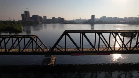 parallel aerial medium shot of and old rail bridge in ottawa now the chief william commanda pedestrian cyclist bridge