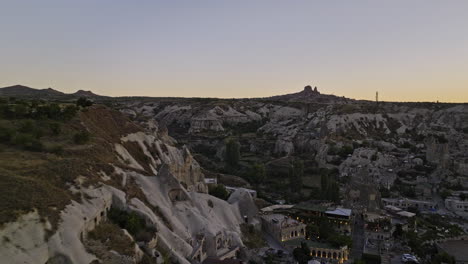 göreme turkey aerial v31 low level flyover high plateau view point capturing ancient town surrounded by landscape of rock formations with sun setting at horizon - shot with mavic 3 cine - july 2022