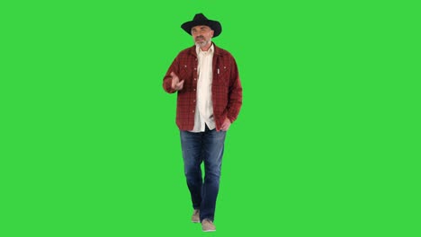 ranch owner in a cowboy hat walking and telling a story on a green screen, chroma key