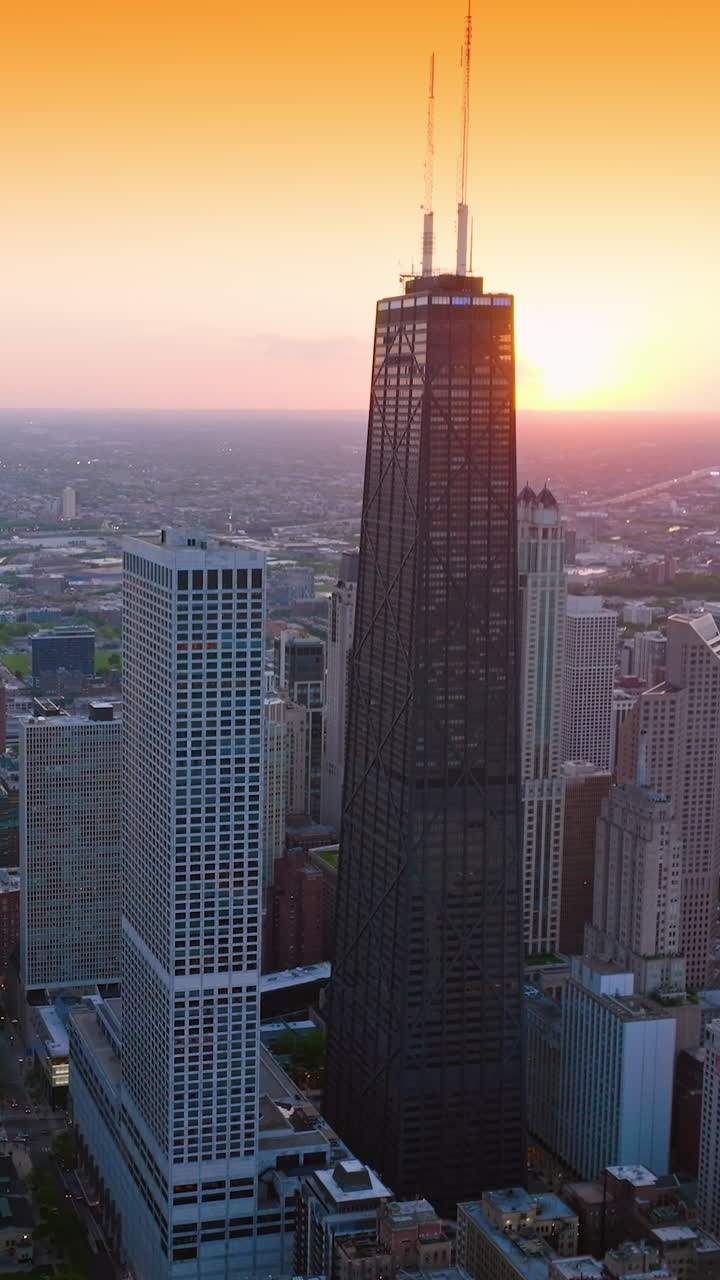 Powerful skyscrapers against the yellow sky at sunset. Chicago cityscape from aerial perspective. Vertical video