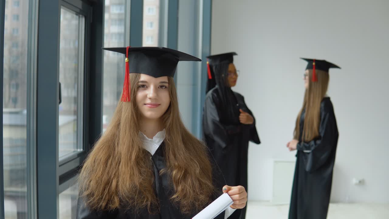 una graduada sonriente sostiene un diploma de educación superior en sus manos con otra estudiante femenina en el fondo. programa internacional de intercambio de estudiantes para grupos socialmente vulnerables