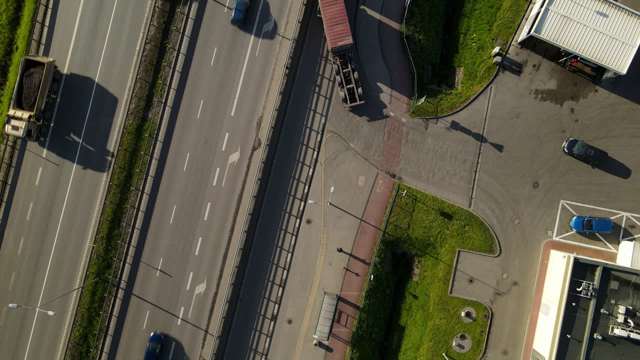 Vista aerea con drone - Mezzi pesanti che lasciano il piazzale per immettersi in autostrada a Danzica, Polonia - Concetto di Trasporto e Spedizione