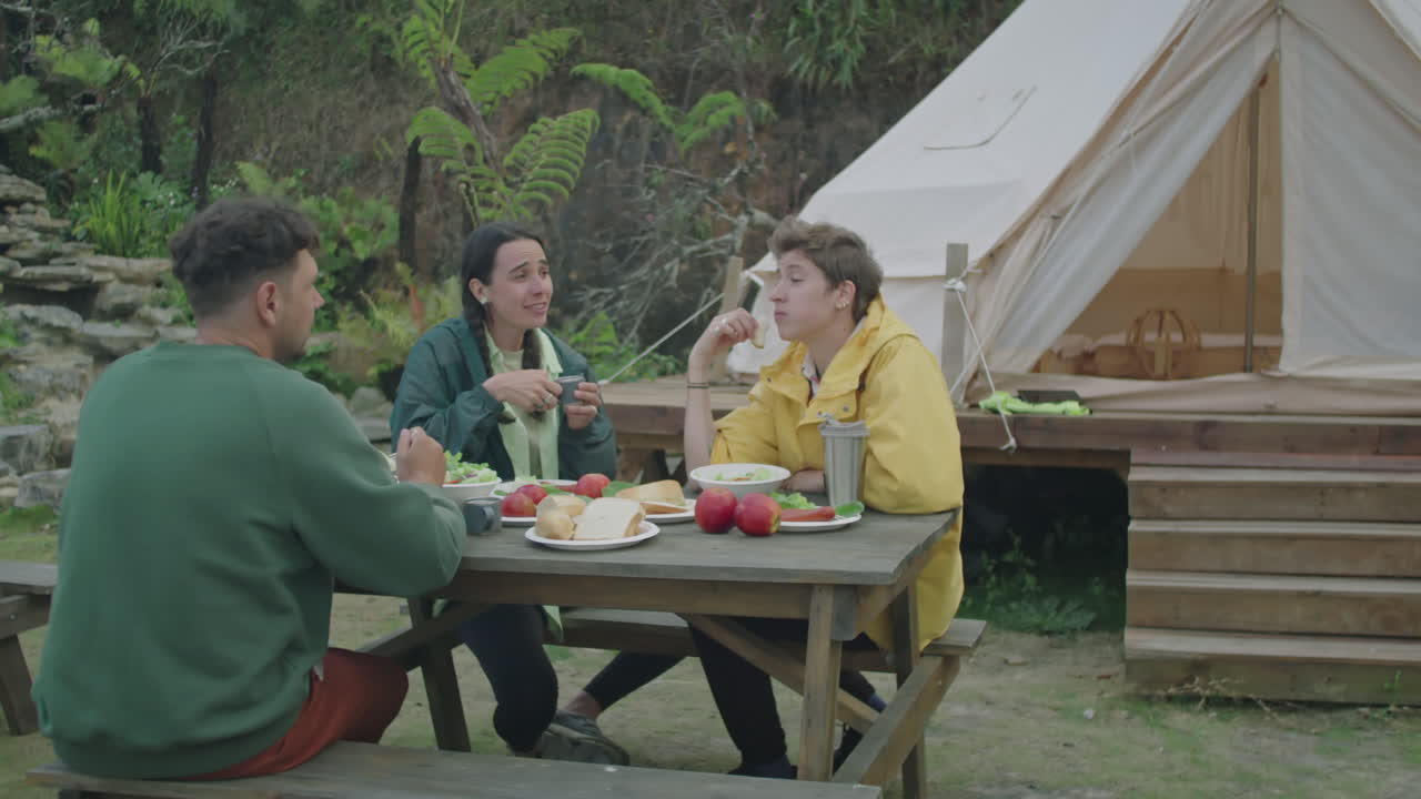 Tourists Enjoying Dinner and Chatting Outside of Glamping Tent