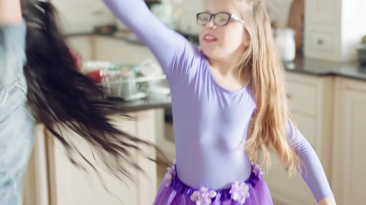Mother and Daughter Dancing Together in Kitchen