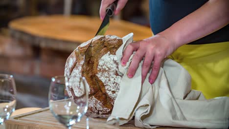 chef cuts black bread on cutting board podvelka, slovenia, slowmo closeup