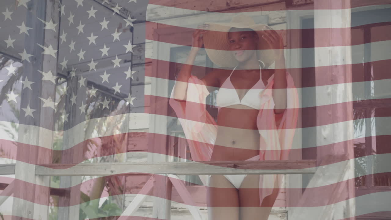 Animation of american flag over happy african american woman wearing hat and bikini in the sun