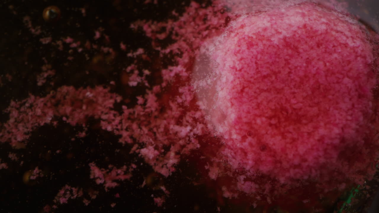 Pink Substance Dissolving in Liquid