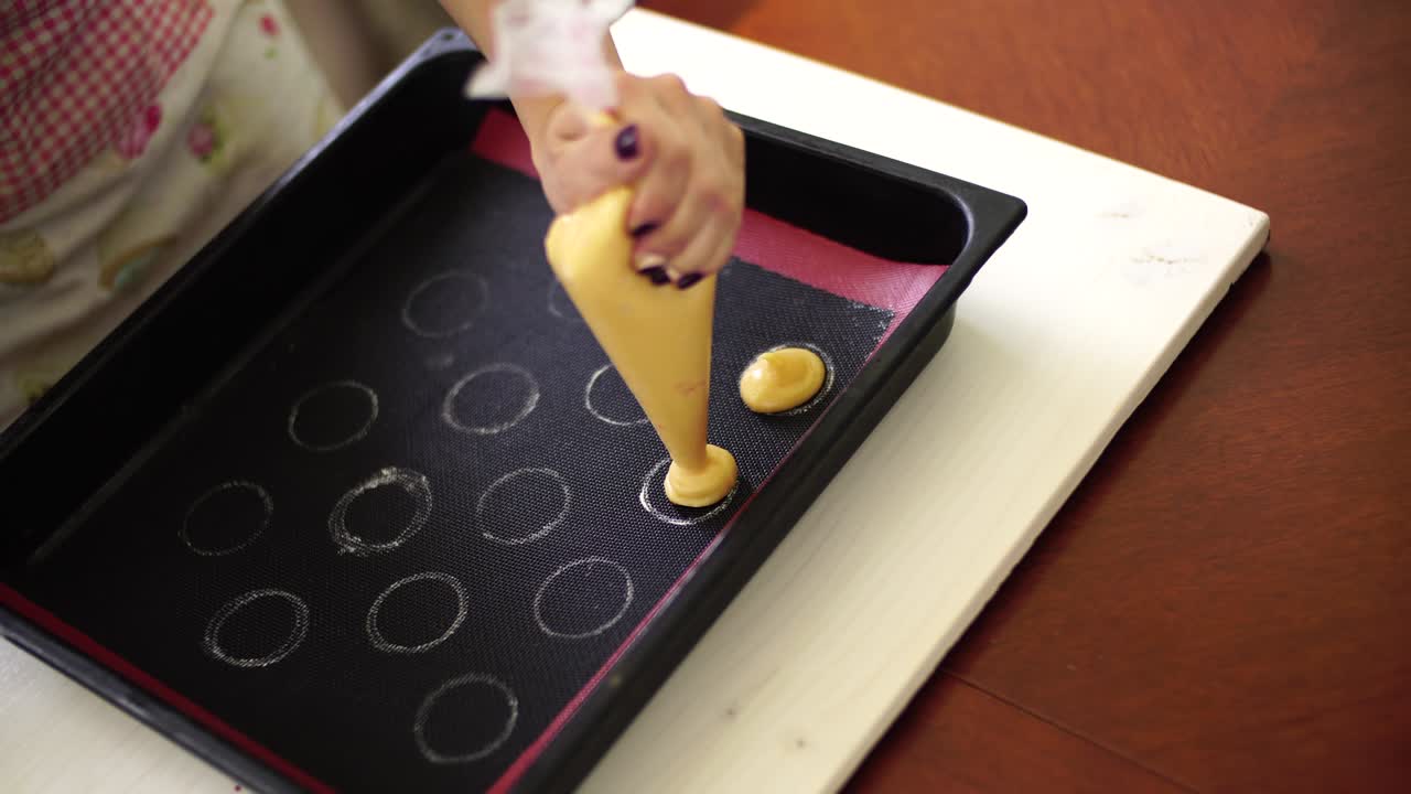 exprimir pasteles de macarrón con una bolsa de pastelería en una alfombra especial