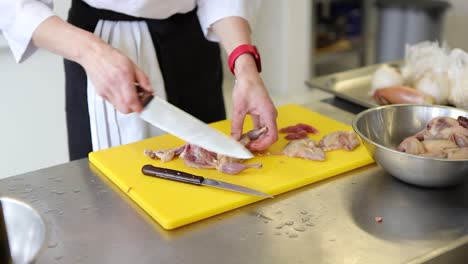 A-chef-cutting-up-and-deboning-a-chicken-on-a-cutting-board