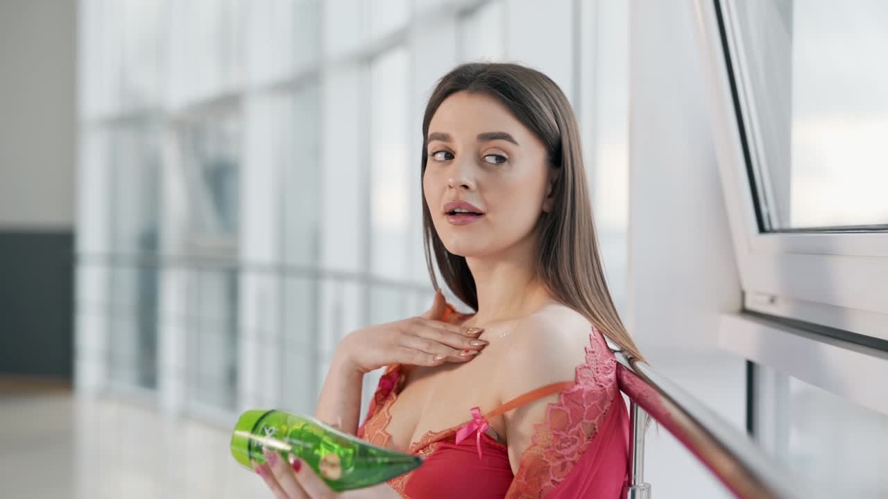 피부에 알로에 크림을 바르는 란제리의 아름다운 여성의 초상화