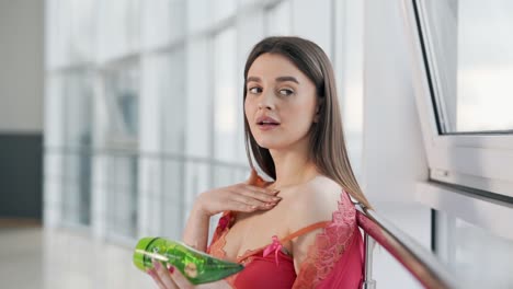 retrato de una bella mujer en lencería aplicando crema de aloe en la piel