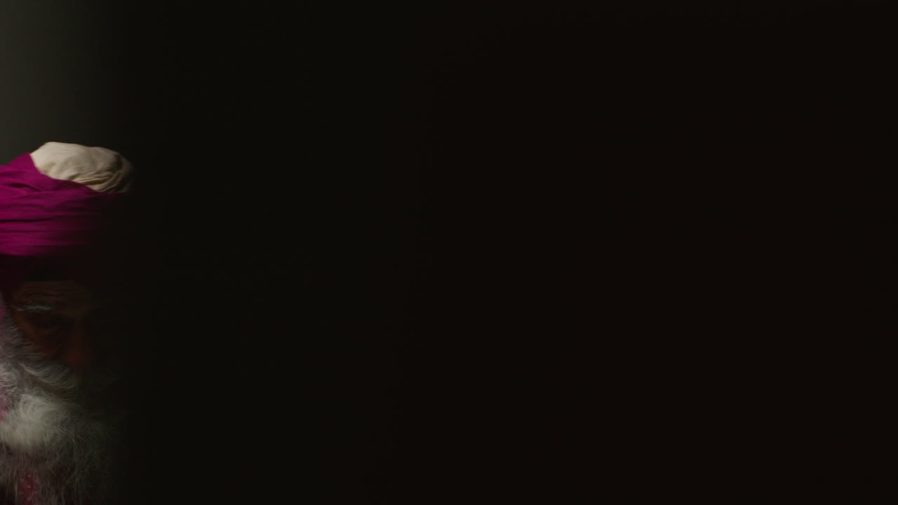 сикх с розовым тюрбаном корректирует свой тюрбан