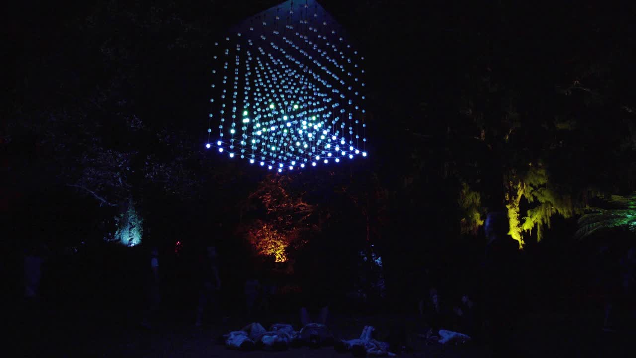 People lying under of a cube of hanging lights