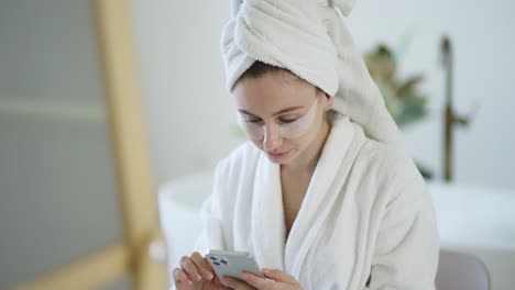 caucasian longhaired woman sitting on a bath and using mobile phone