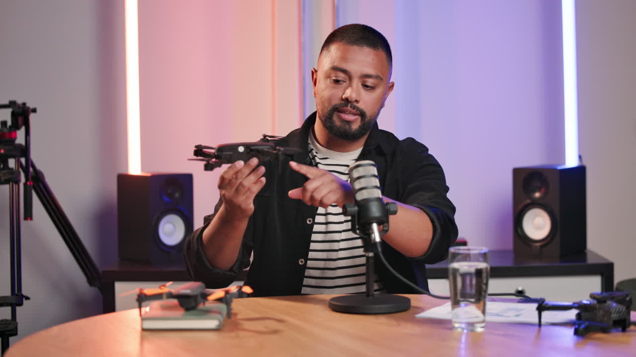 Man holding a drone in a podcast studio