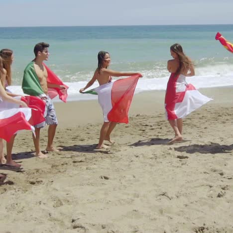 Gruppe-Von-Freunden-In-Badeanzügen-Mit-Flaggen-Am-Strand