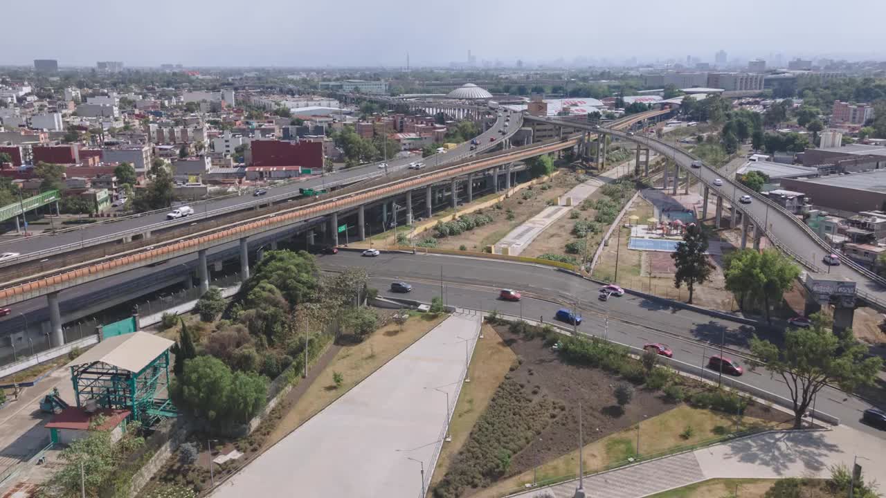 un cruce de autopista ocupado en un paisaje urbano extenso durante el día, vista aérea, hiperlapso