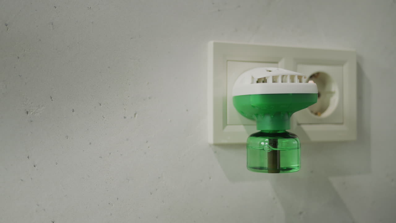 A man plugs a fumigator into an electrical outlet - a device for exterminating mosquitoes