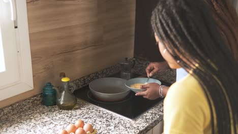 two women preparing eggs in the kitchen
