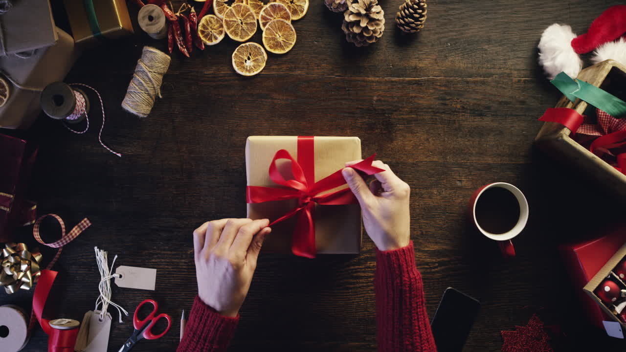 vista superior manos desempaquetando regalos de navidad en un escritorio de madera desde arriba - dragón épico rojo