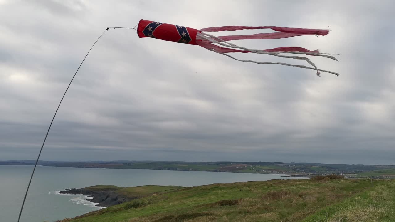 흐린 해안을 배경으로 바람에 흔들리는 패러글라이더의 윈드삭