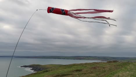 Manga-De-Viento-De-Parapente-Ondeando-En-El-Viento-Con-Un-Fondo-Costero-Nublado