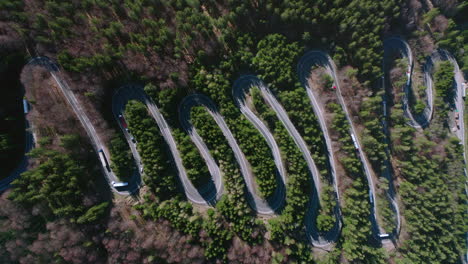 Lento-Ascenso-Aéreo-Por-Encima-Del-Tráfico-En-La-Sinuosa-Carretera-Del-Paso-Bratocea,-Rumania