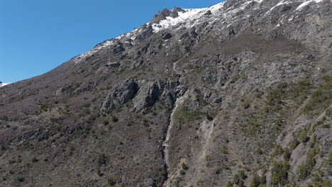 Aerial view of snowy rocky mountain with waterfall on Route 40, San Martin de los Andes, Patagonia, Neuquén, Argentina