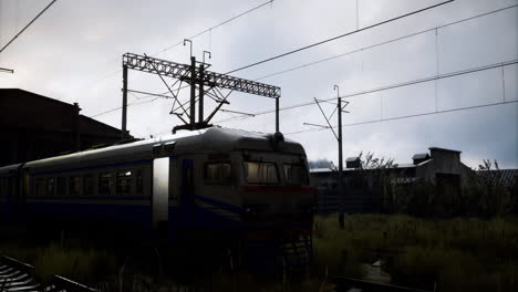 train waits at the deserted platform under a cloudy sky in the evening