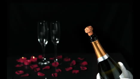 Champagne-cork-popping-in-front-of-two-flutes