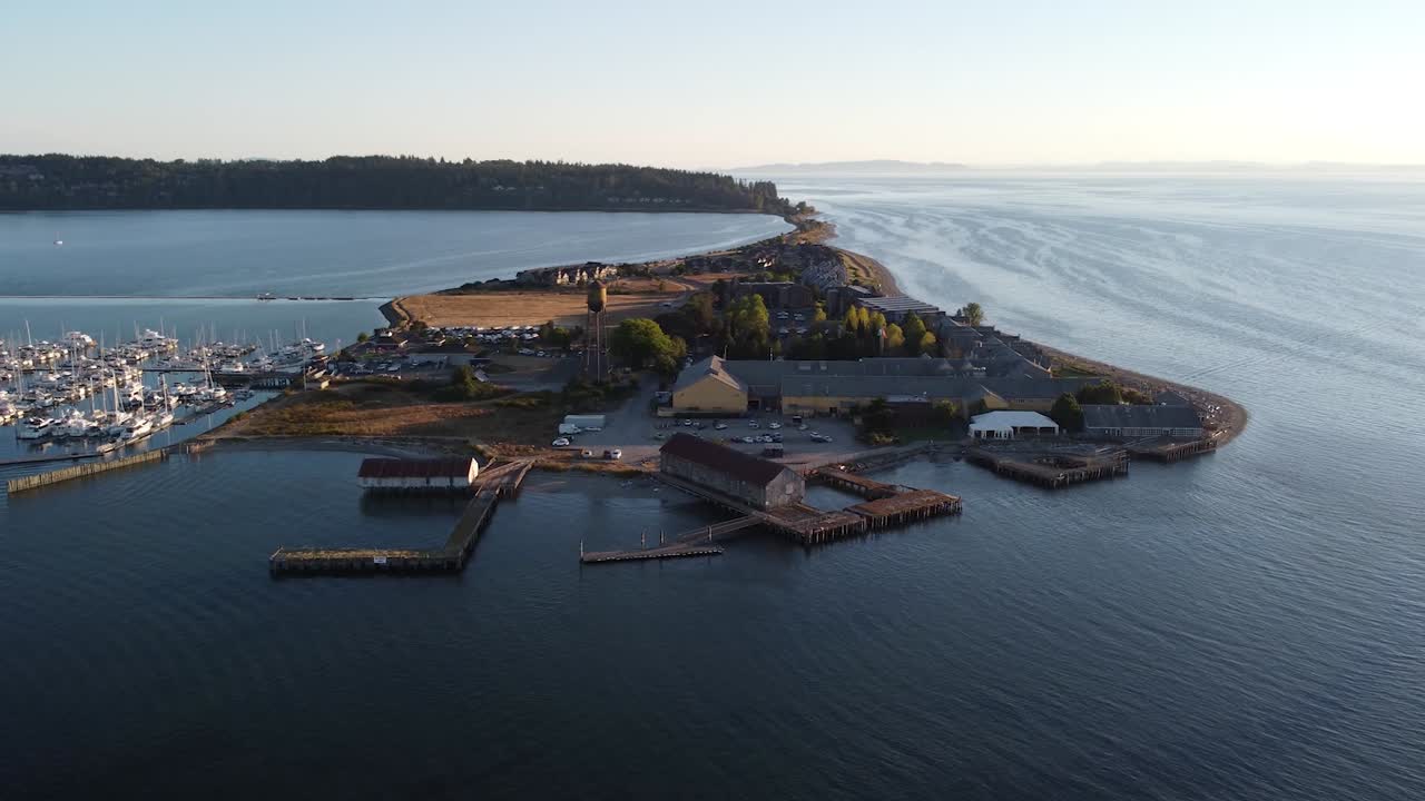 Ilmakuva satamasta, joka liikkuu vintage-vesitornin ohi Semiahmoon lomakeskuksessa. Näkymä turkoosinsinisellä merellä risteileville veneille Semiahmoossa, Washingtonissa, lähellä Seattlea auringonlaskun aikaan